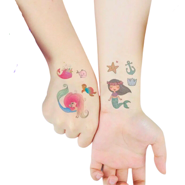 Girls arms displaying temporary tattoos of mermaids starfish and other underwater creatures