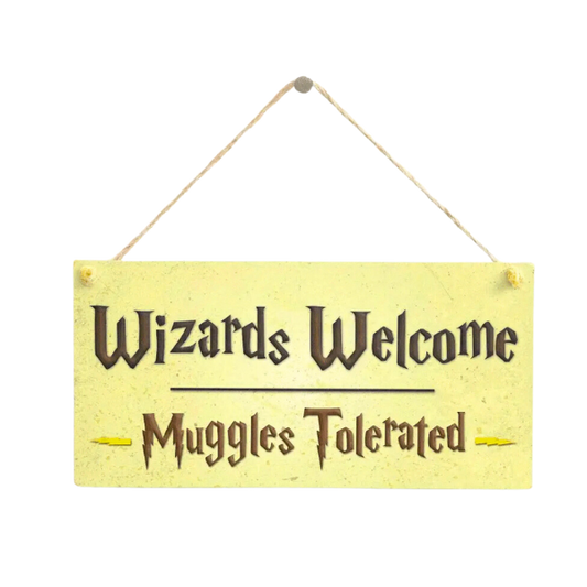 Yellow wall sign with black writing saying Wizards welcome, muggles tolerated